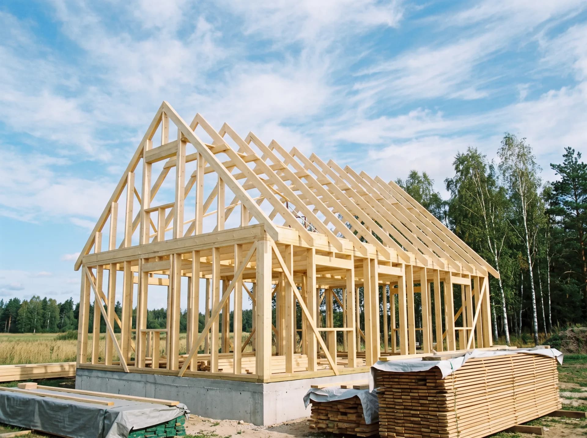 Timber frame walls and roof trusses standing on a new house